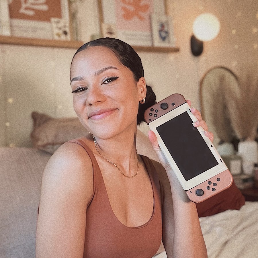 Cozy K holding a handheld gaming console in her official channel photo